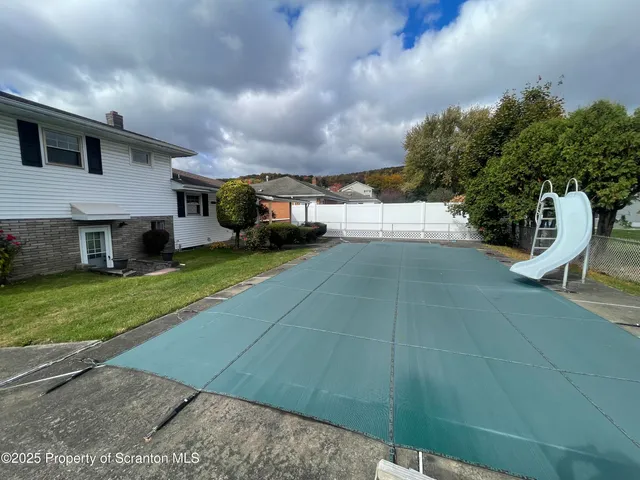 a view of a house with backyard and sitting area