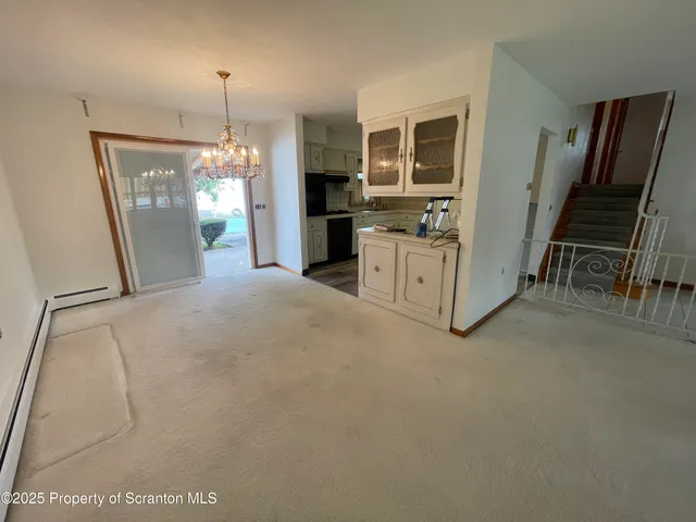 a large white kitchen with granite countertop a refrigerator oven a sink dishwasher and a fireplace