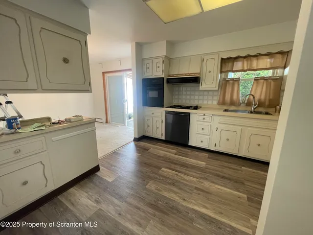 a kitchen with granite countertop a stove top oven sink and cabinets