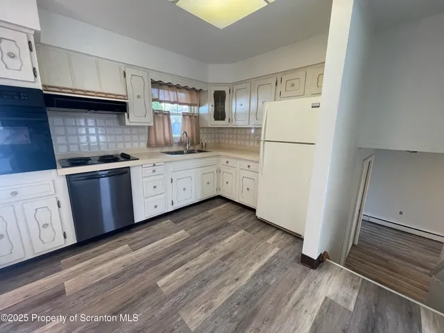 a kitchen with granite countertop white cabinets and white appliances