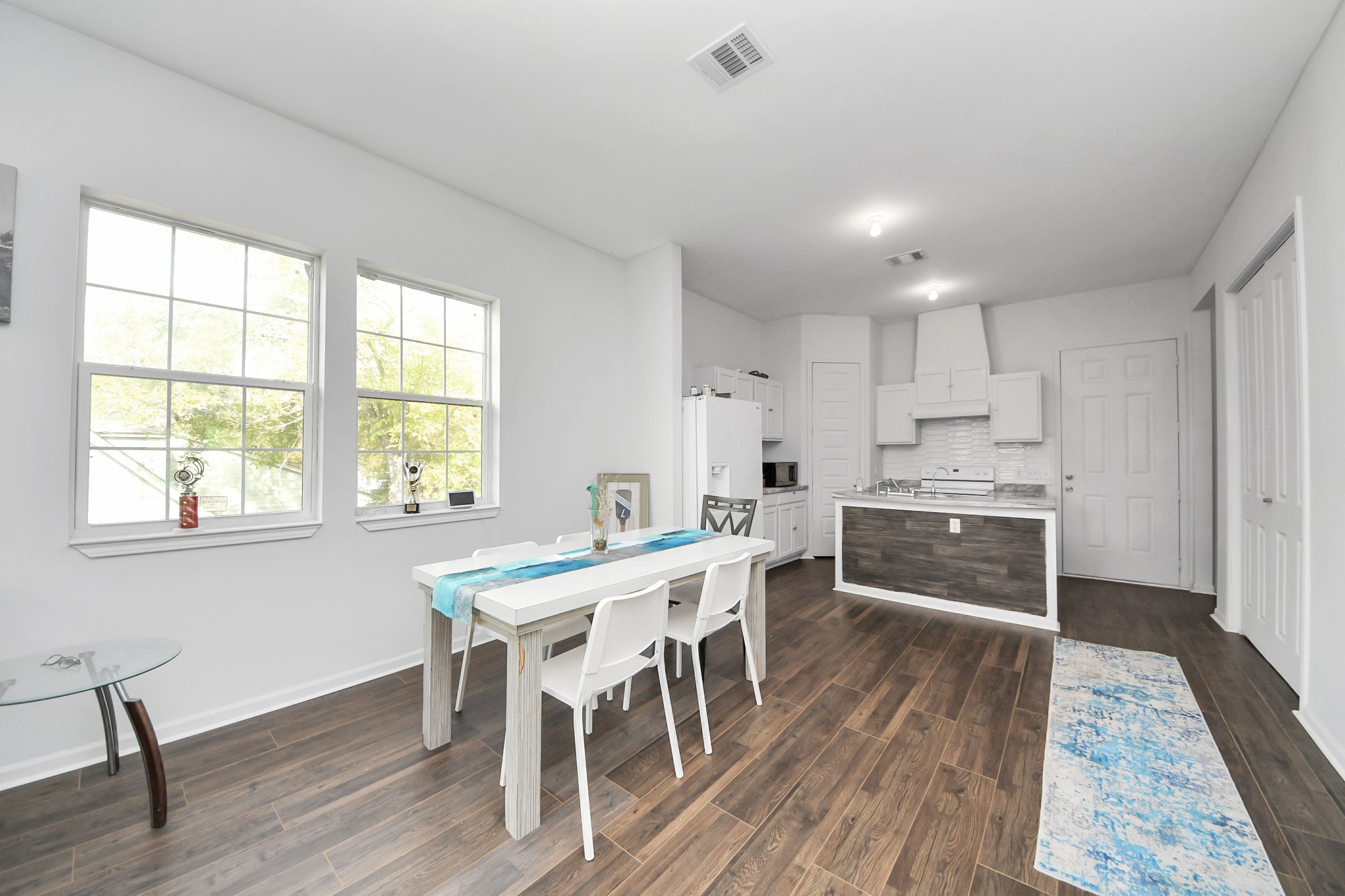 3011 Layne Street La Porte, TX 77571 - Photo 14 of 41 a kitchen with stainless steel appliances a stove a sink dishwasher white cabinets and wooden floor