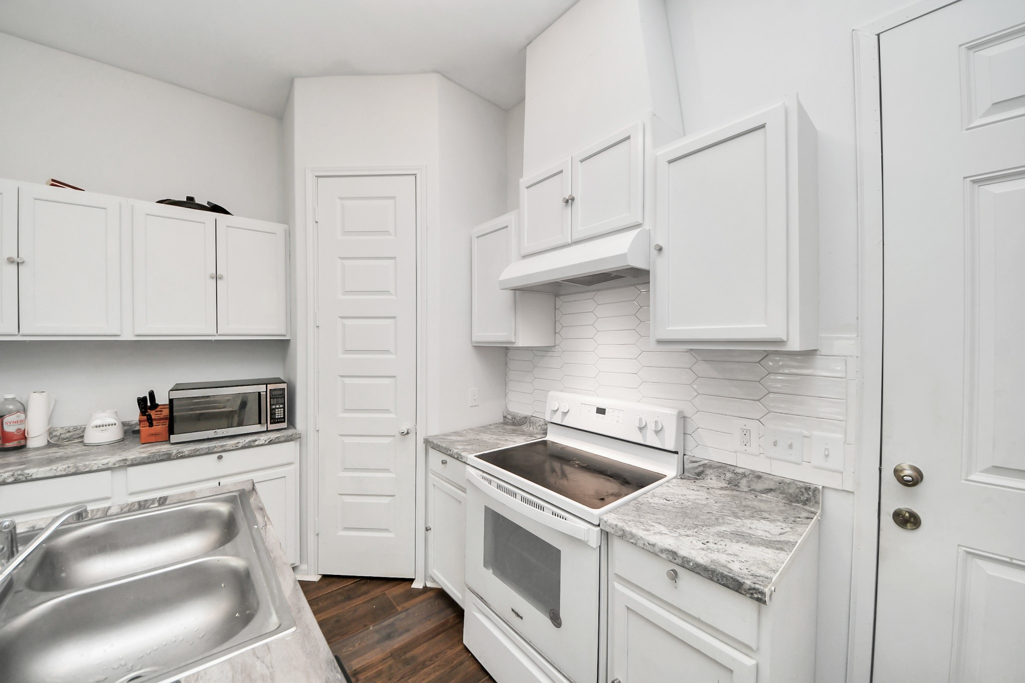 3011 Layne Street La Porte, TX 77571 - Photo 21 of 41 a kitchen with white cabinets and white appliances