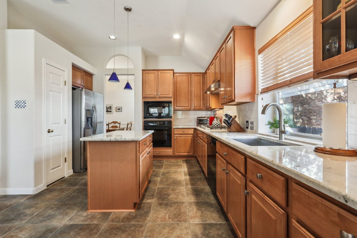 3805 Pebble Court Round Rock, TX 78664 - Photo 16 of 31 a kitchen with kitchen island granite countertop a sink a counter top space stainless steel appliances and cabinets