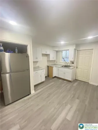 a kitchen with stainless steel appliances granite countertop a stove a sink and white cabinets