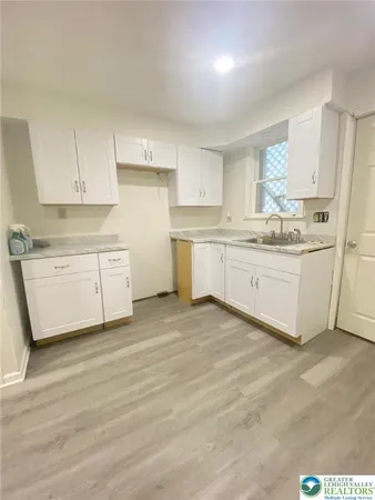 a view of a kitchen with white cabinets