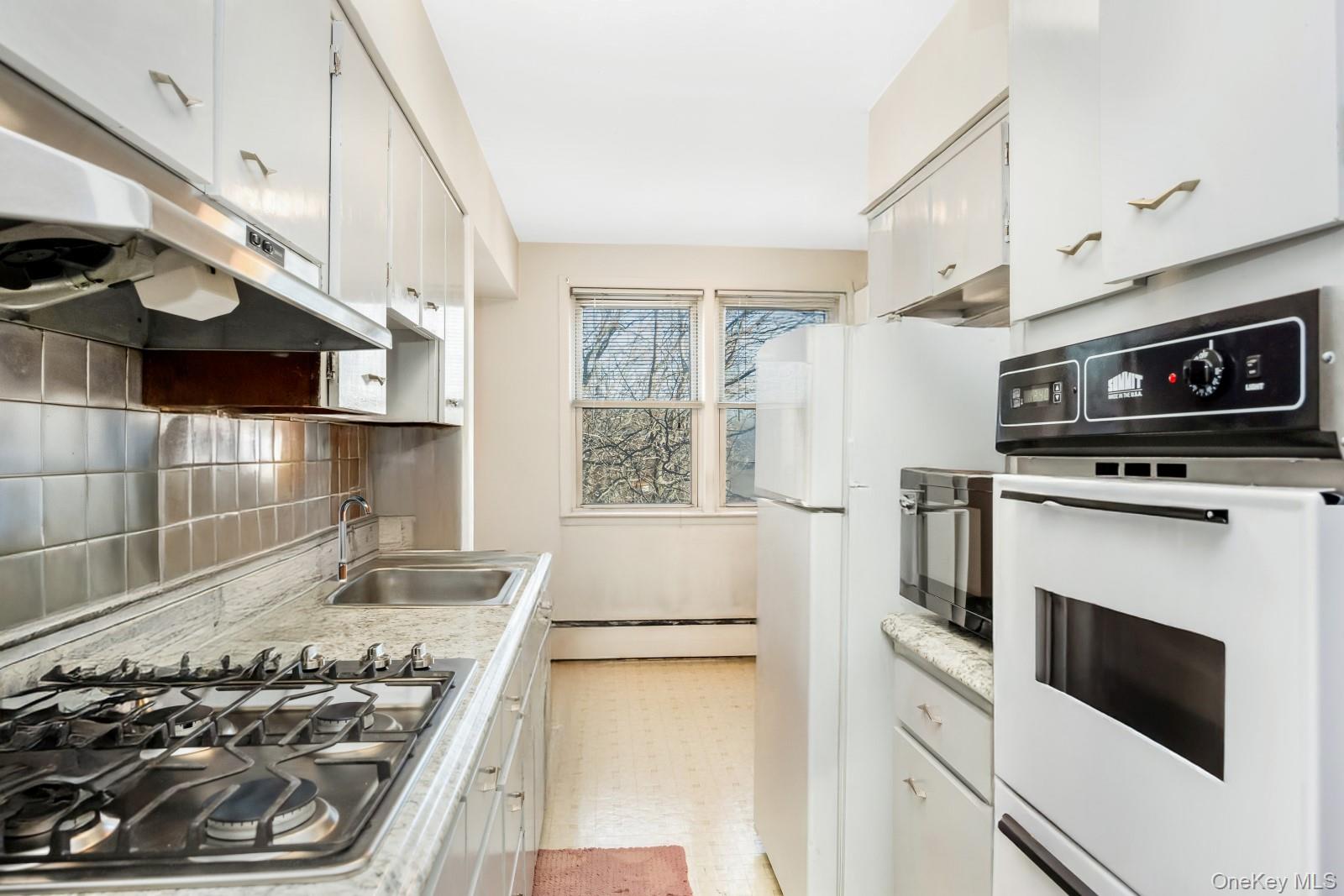 60-56 75th Street Queens, NY 11379 - Photo 17 of 30 a kitchen with a stove and a microwave