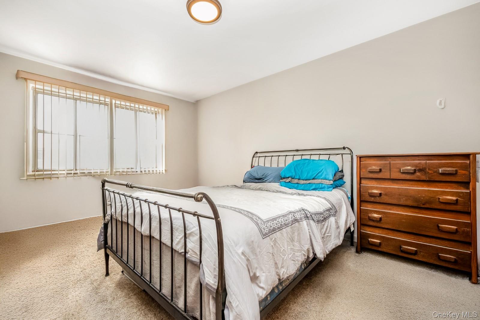 60-56 75th Street Queens, NY 11379 - Photo 20 of 30 a bedroom with a bed and a window