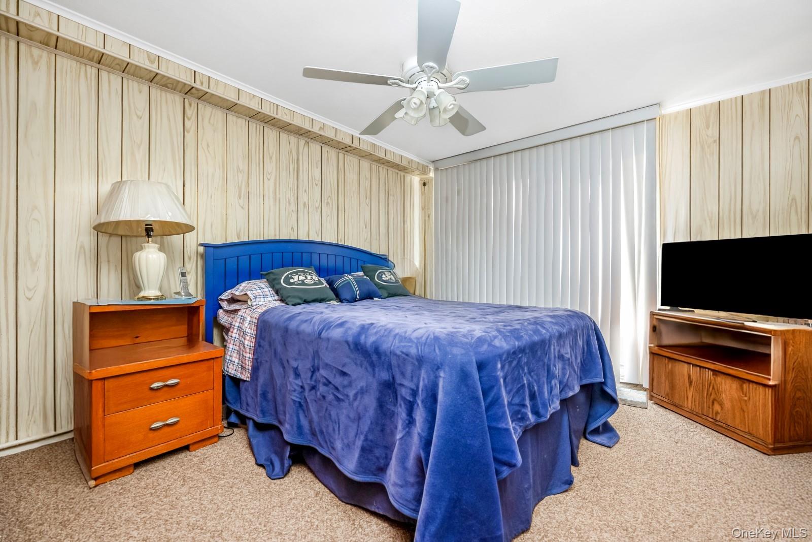 60-56 75th Street Queens, NY 11379 - Photo 22 of 30 a bedroom with a bed and a flat tv screen on dresser