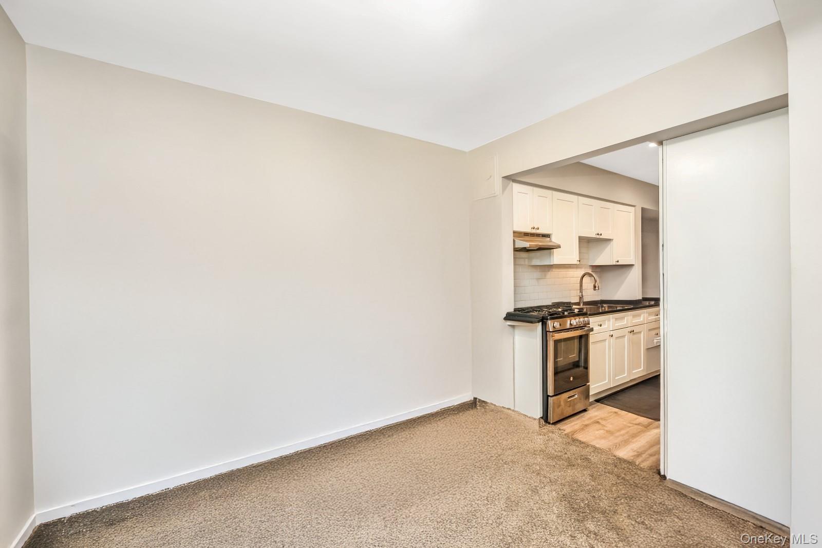 60-56 75th Street Queens, NY 11379 - Photo 6 of 30 a kitchen with granite countertop a stove top oven and sink
