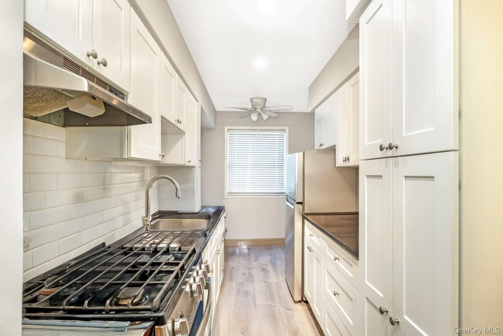 60-56 75th Street Queens, NY 11379 - Photo 7 of 30 a kitchen with granite countertop a stove and a refrigerator