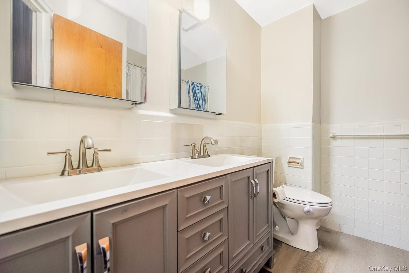 60-56 75th Street Queens, NY 11379 - Photo 10 of 30 a bathroom with a granite countertop toilet sink and mirror