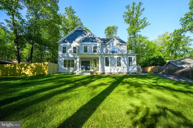 a view of a house with a big yard plants and large trees