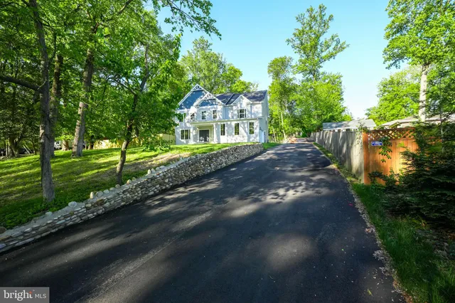 a front view of a house with a yard and green space