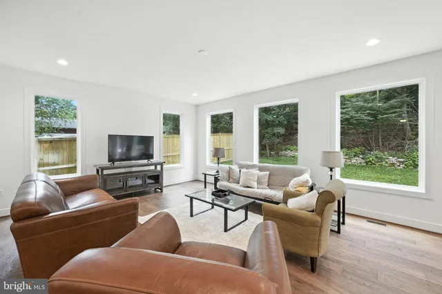 a living room with furniture a flat screen tv and a large window