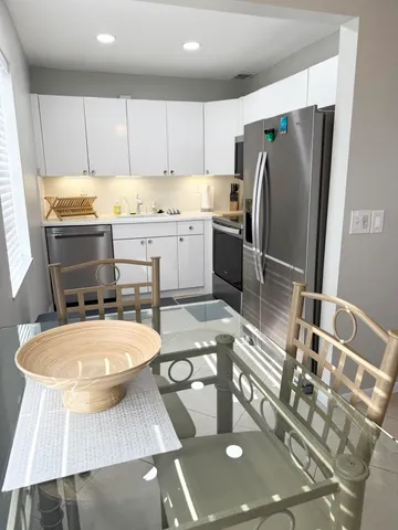 a kitchen with stainless steel appliances a sink a refrigerator and wooden cabinets