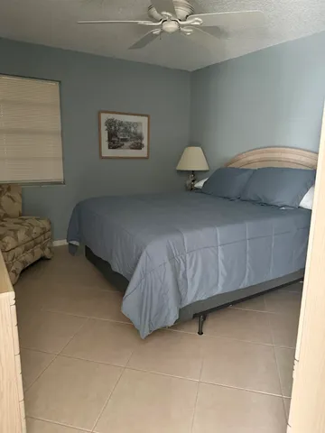 a bedroom with a bed and ceiling fan