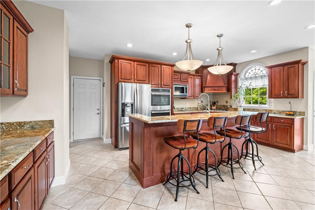 110 Marcur Lane Monaca, PA 15061 - Photo 14 of 50 a kitchen with stainless steel appliances granite countertop a stove a sink a oven with a dining table and chairs