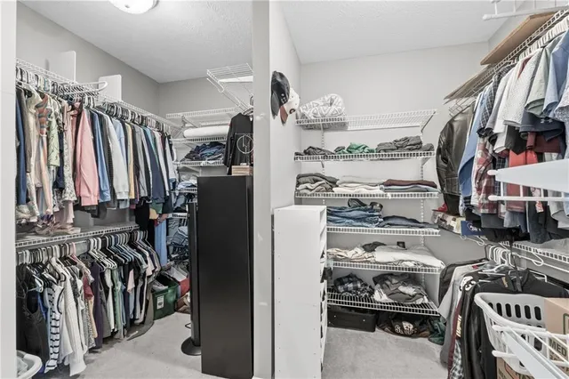a view of walk in closet with clothes and shoes