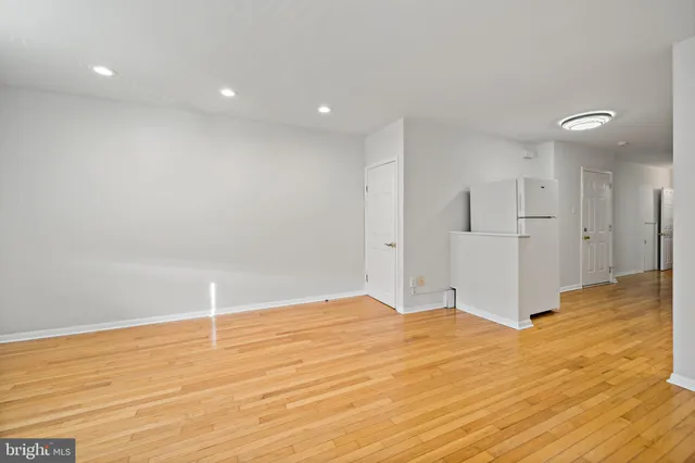a view of empty room with wooden floor