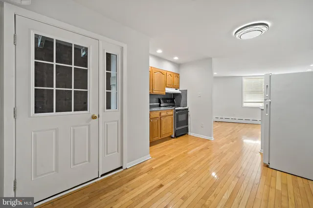 a view of a kitchen with wooden floor and windows