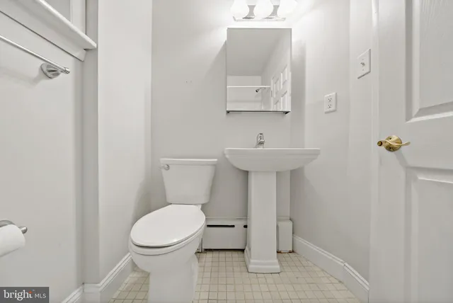 a bathroom with a toilet sink and mirror