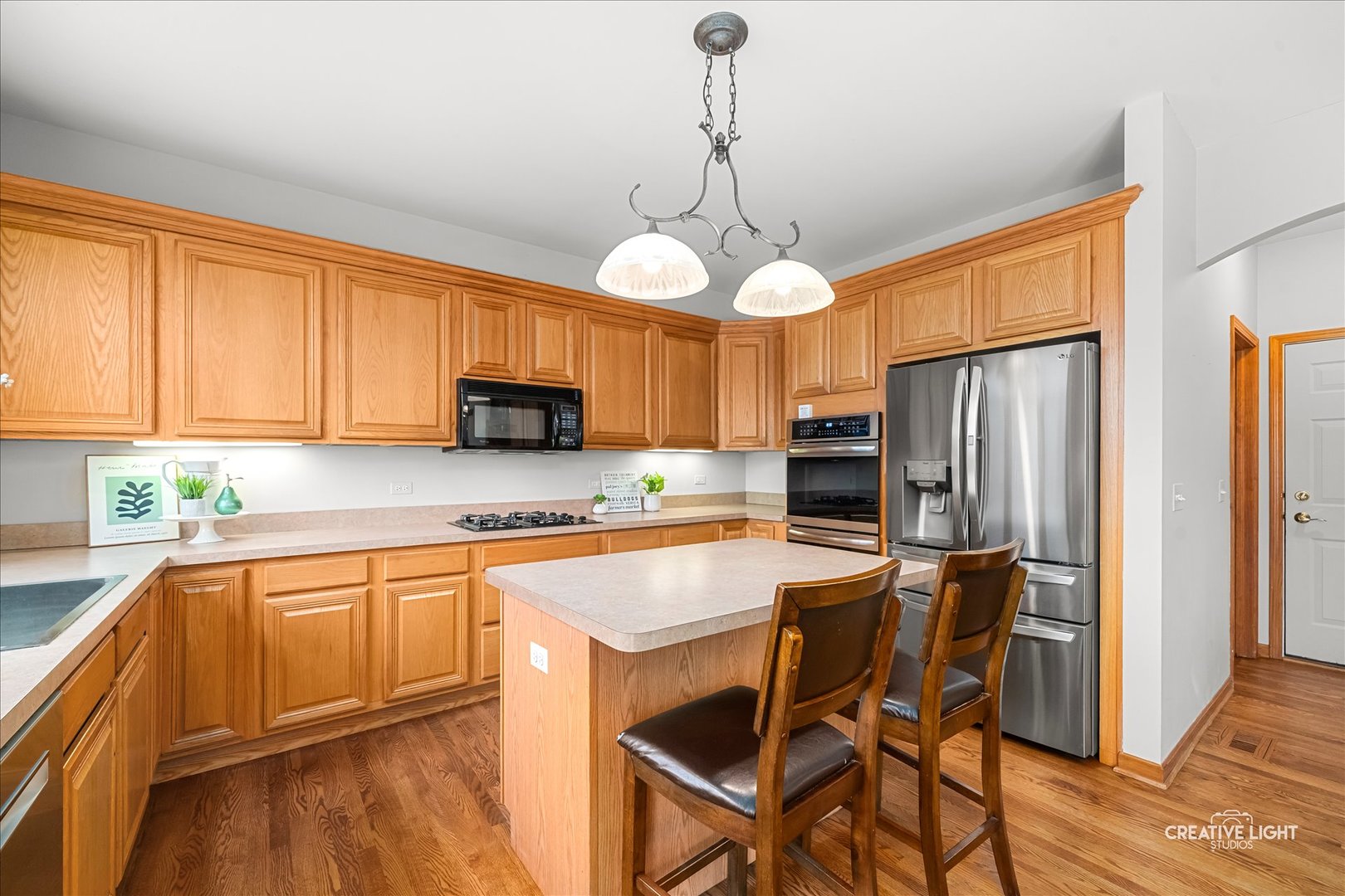 201 Violet Lane Batavia, IL 60510 - Photo 19 of 47 a kitchen with stainless steel appliances granite countertop a refrigerator a sink dishwasher a stove and white cabinets with wooden floor