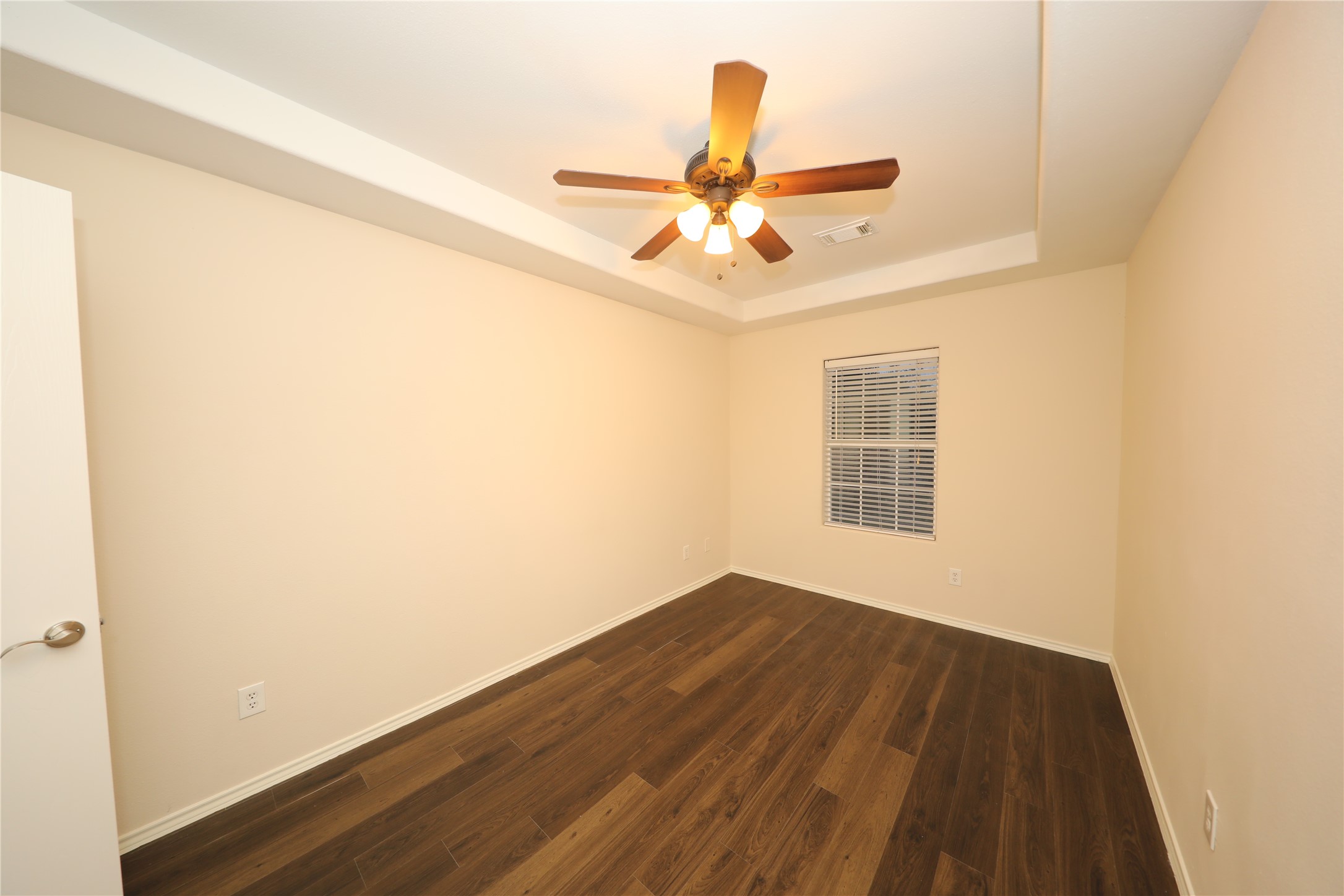 12620 Rio Bravo Street Rosharon, TX 77583 - Photo 12 of 25 a view of an empty room with wooden floor and a window