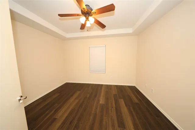 an empty room with a window and a ceiling fan