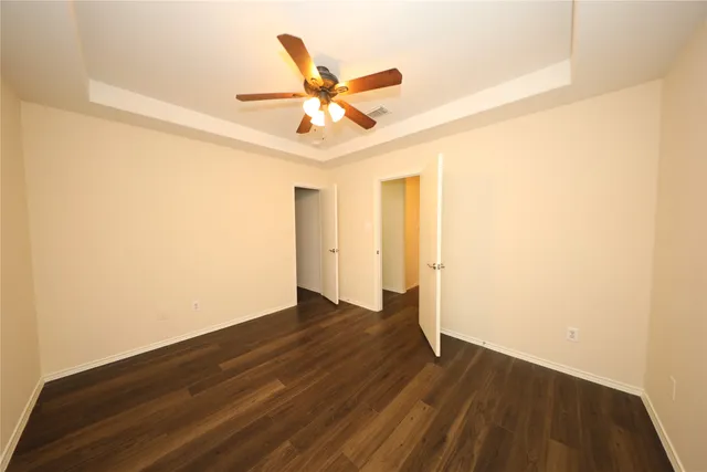 a view of a room with wooden floor and a ceiling fan