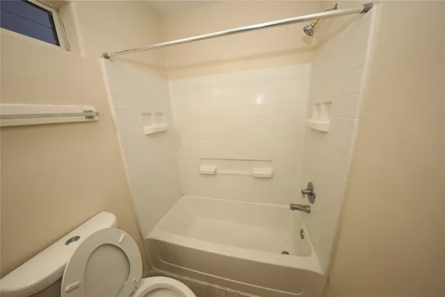 a bathroom with a shower a toilet and a sink