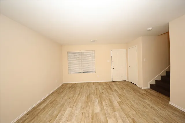 a view of a room with wooden floor and white walls