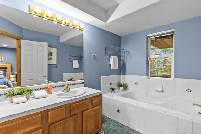 a bathroom with a tub sink and mirror