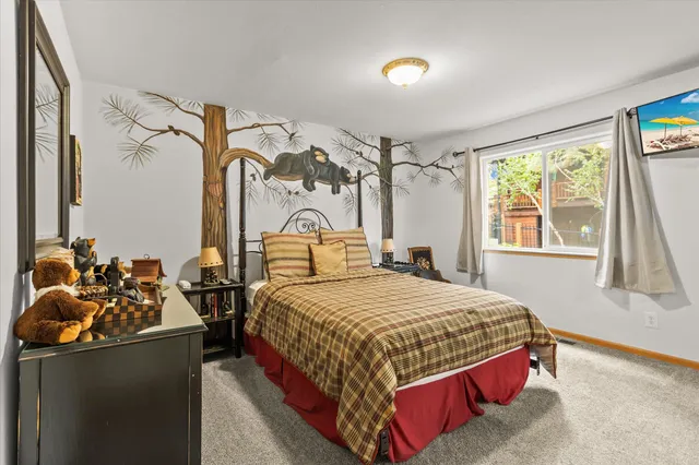 a bedroom with a bed and a dresser next to a window