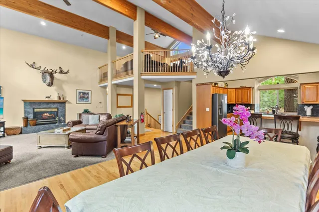 a view of a dining room with furniture a chandelier and large windows