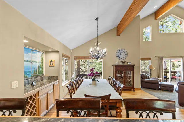 a view of a dining room with furniture a chandelier and wooden floor
