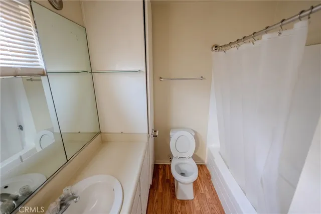 a kitchen with kitchen island wooden floors appliances and cabinets