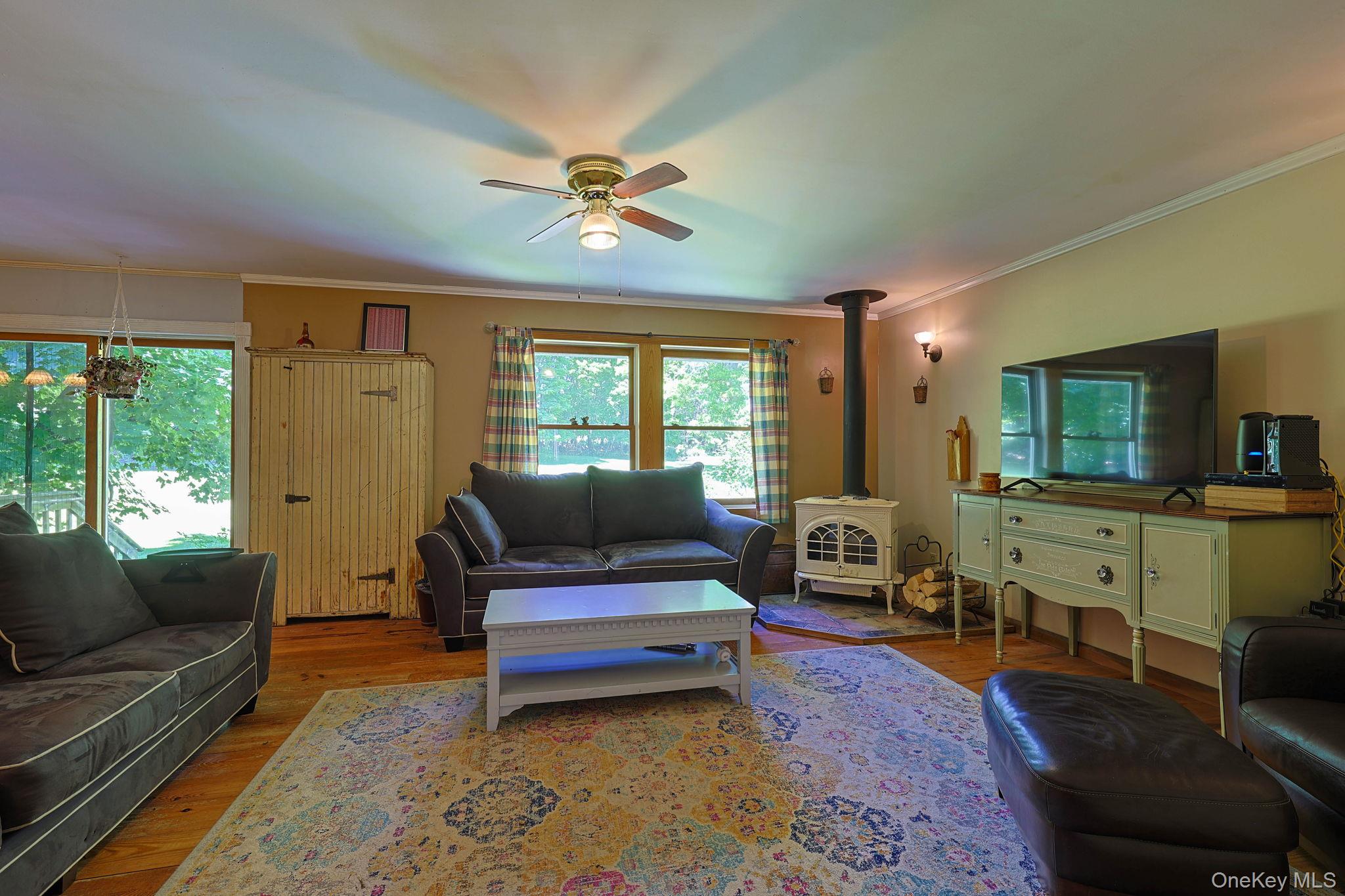 646 County Rte 93 Slate Hill, NY 10973 - Photo 3 of 21 Spacious interior featuring wood-finish flooring, a ceiling fan, and multiple windows providing natural light