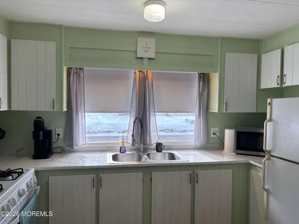a kitchen with stainless steel appliances granite countertop a sink and a refrigerator