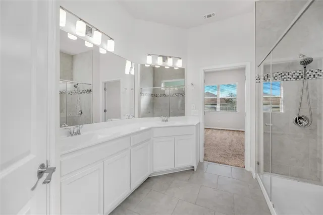 a spacious bathroom with a double vanity sink mirror and shower