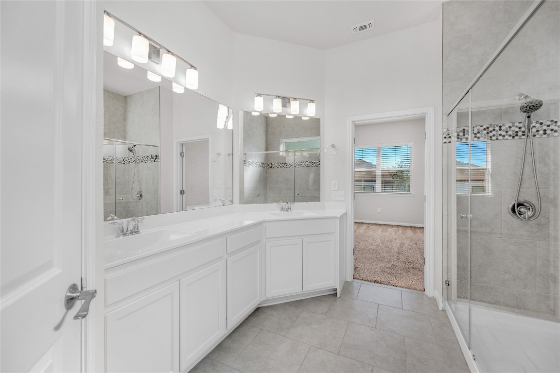 9941 Comely Bend Manor, TX 78653 - Photo 12 of 31 a spacious bathroom with a double vanity sink mirror and shower