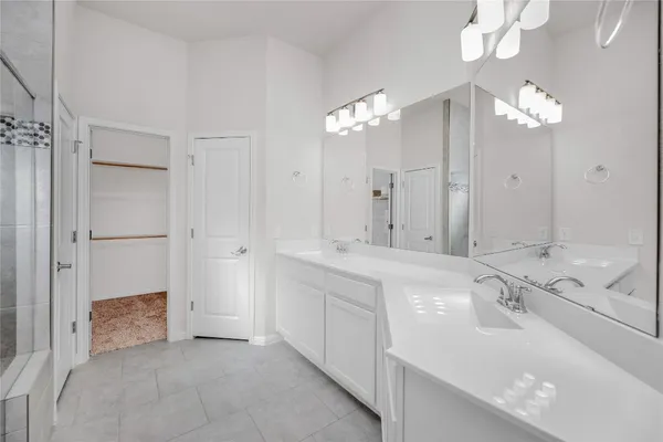 a spacious bathroom with a double vanity sink mirror and shower