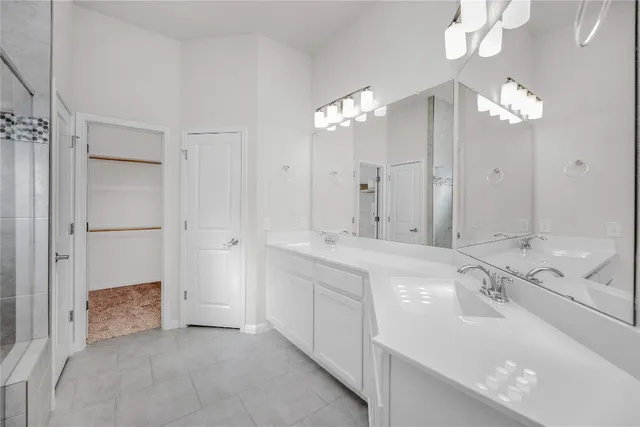 a spacious bathroom with a double vanity sink mirror and shower