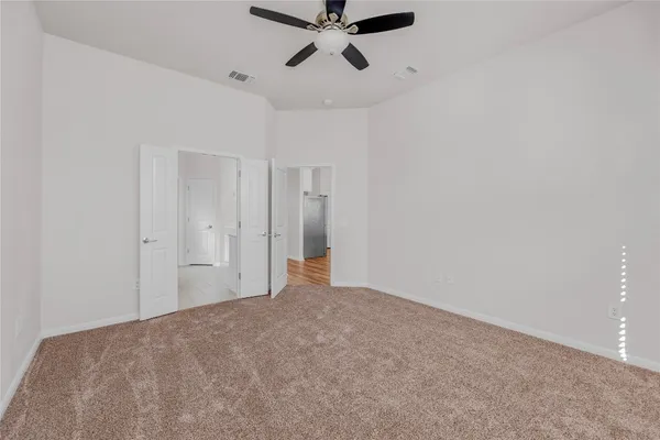 a view of empty room with ceiling fan
