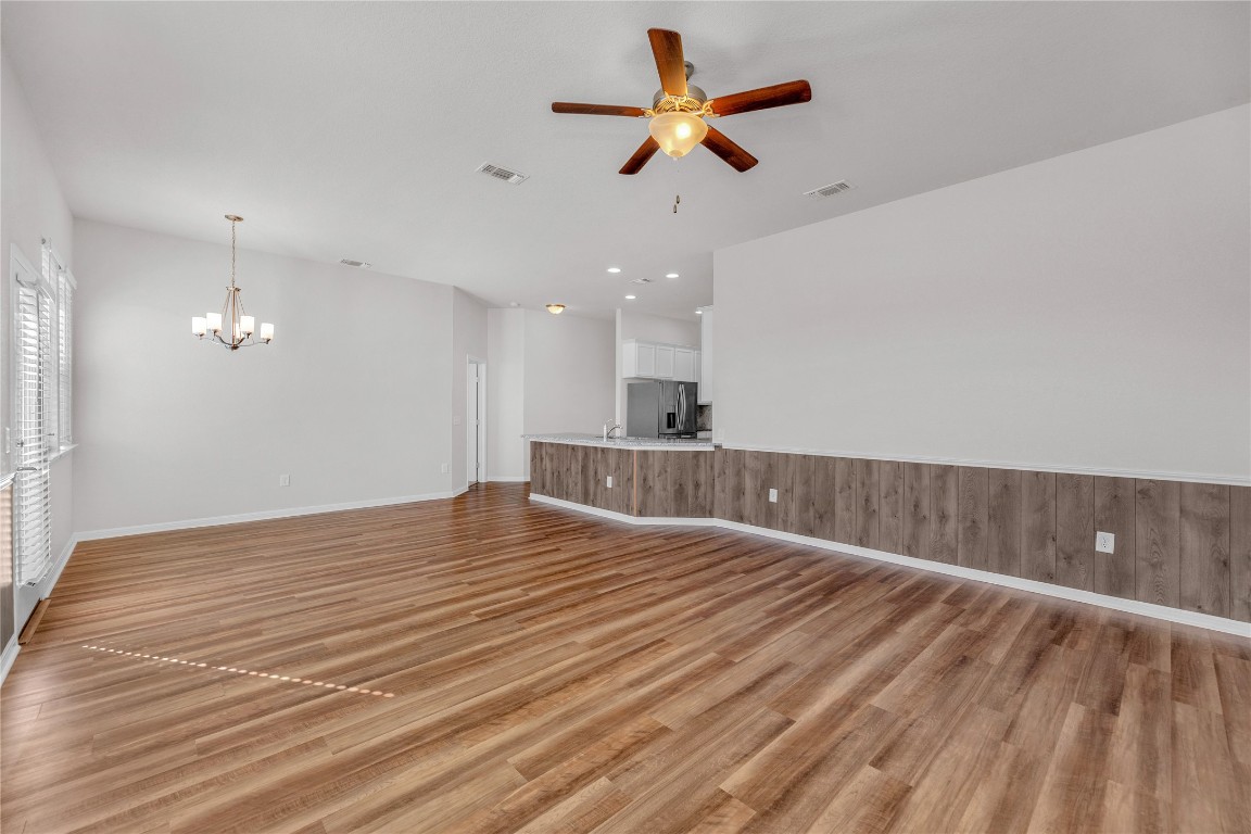9941 Comely Bend Manor, TX 78653 - Photo 26 of 31 a view of an empty room with wooden floor and a ceiling fan
