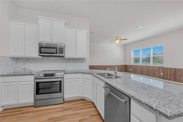 a kitchen with granite countertop a sink and a stove