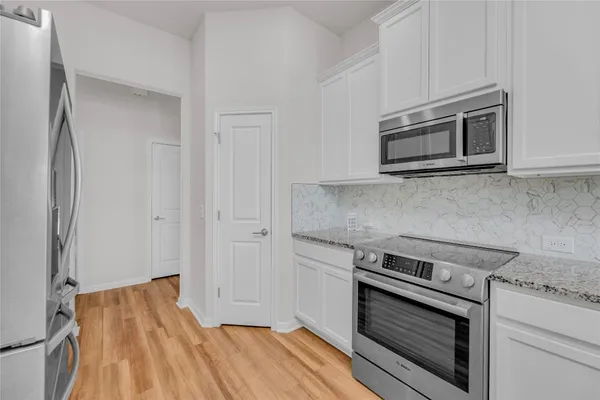 a kitchen with granite countertop wooden cabinets and stainless steel appliances