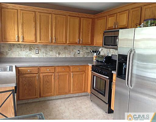 1806 Ridgeview Court Sayreville, NJ 08859 - Photo 3 of 7 a kitchen with granite countertop a stove top oven microwave and cabinets
