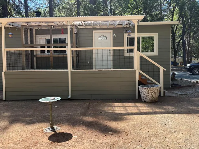 a view of a blue house with a bench in front of it
