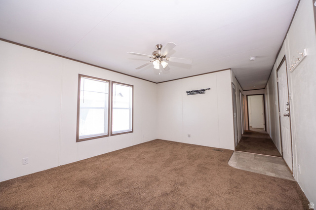 2491 Highway 89, Unit 403 Pleasant View, UT 84404 - Photo 5 of 32 Spacious living area featuring brown carpeting, white paneled walls, and dark trim