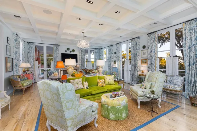 a living room with furniture kitchen view and a large window